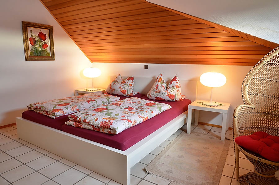 Individuell eingerichtetes Schlafzimmer mit Doppelbett, Schrank und Kommode.