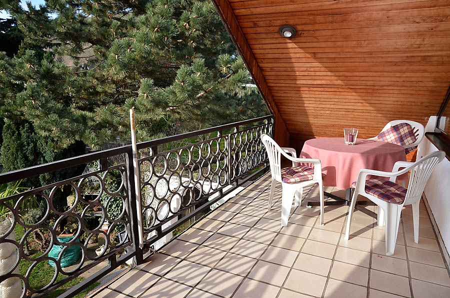 Übedachter Balkon mit Panoramablick in den Garten, auf die Rebflächen und den Pfälzerwald.